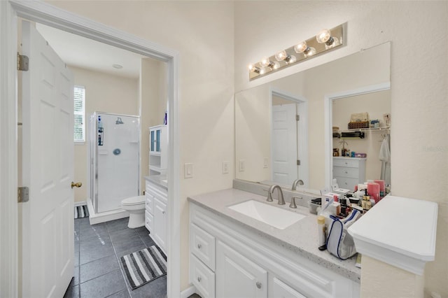 bathroom featuring walk in shower, vanity, toilet, and tile patterned floors