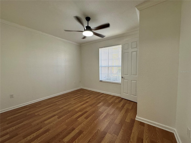 spare room featuring dark wood-style floors, a ceiling fan, baseboards, and ornamental molding