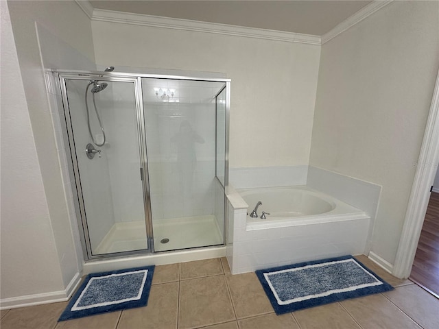 full bath featuring tile patterned flooring, a shower stall, baseboards, a garden tub, and ornamental molding