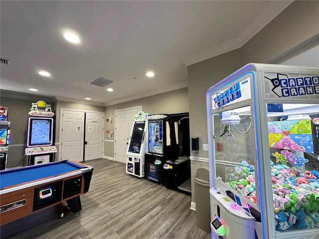 recreation room featuring recessed lighting, wood finished floors, visible vents, and ornamental molding