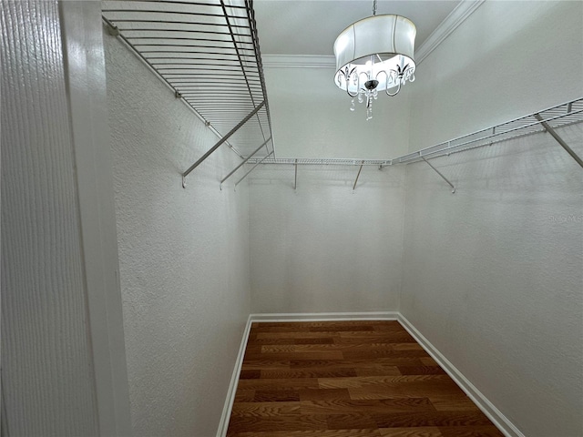 walk in closet featuring a notable chandelier and wood finished floors