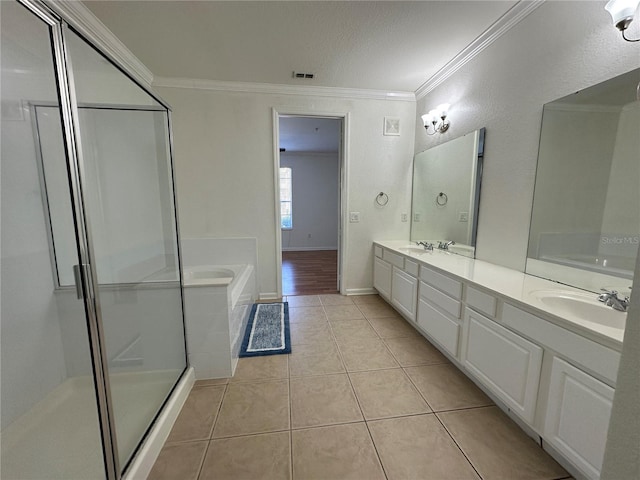 bathroom with double vanity, ornamental molding, tile patterned flooring, a sink, and a bath