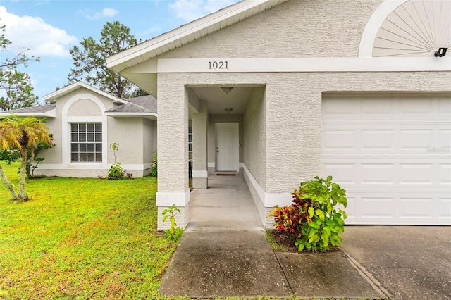 doorway to property with a lawn and a garage