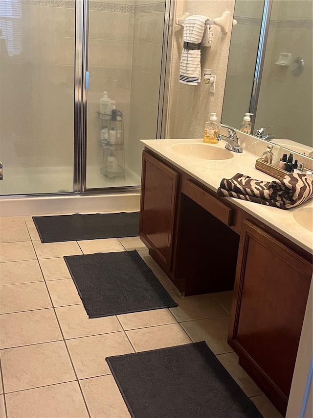 bathroom featuring vanity, a shower with door, and tile patterned floors