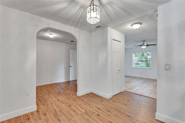 unfurnished room featuring ceiling fan, a textured ceiling, and light hardwood / wood-style floors