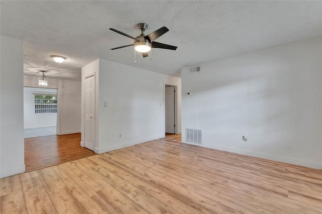 unfurnished room featuring light hardwood / wood-style flooring, a textured ceiling, and ceiling fan with notable chandelier