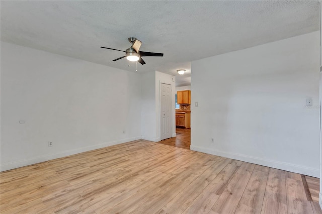 empty room with light wood-type flooring, a textured ceiling, and ceiling fan