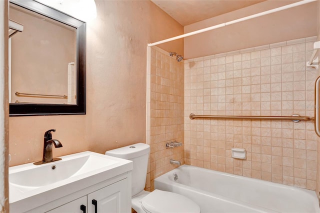 full bathroom featuring vanity, tiled shower / bath combo, and toilet