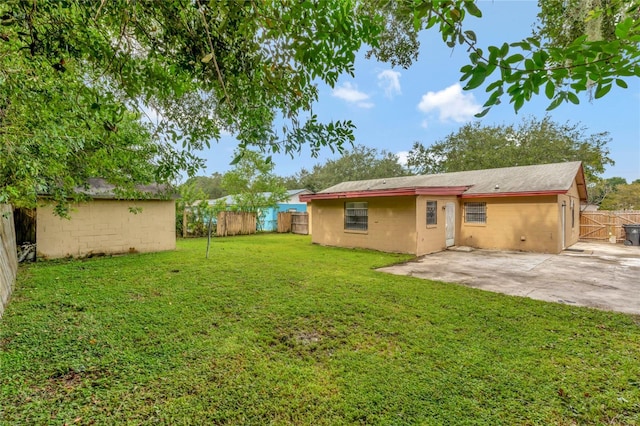 back of property with a lawn and a patio