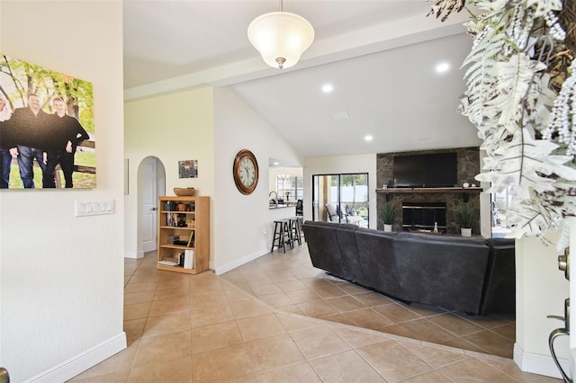 living room with a fireplace, vaulted ceiling, and light tile patterned floors