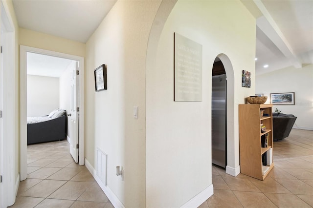 corridor with light tile patterned flooring and lofted ceiling with beams