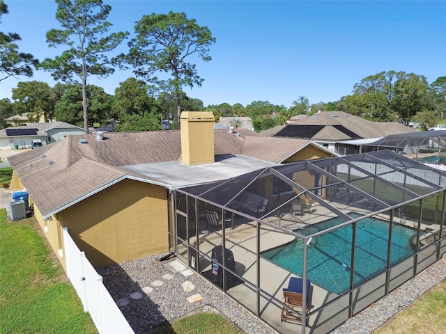 view of pool featuring glass enclosure and a patio area