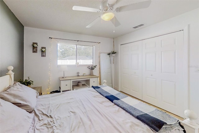 bedroom with ceiling fan, a textured ceiling, and a closet