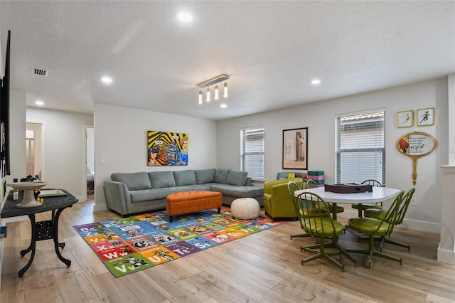 living room featuring a textured ceiling and light hardwood / wood-style floors