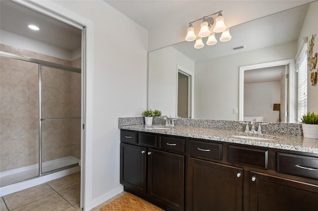 bathroom featuring tile patterned flooring, a shower with shower door, and vanity