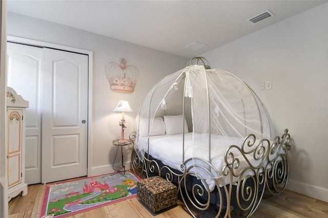 bedroom with hardwood / wood-style floors and a closet