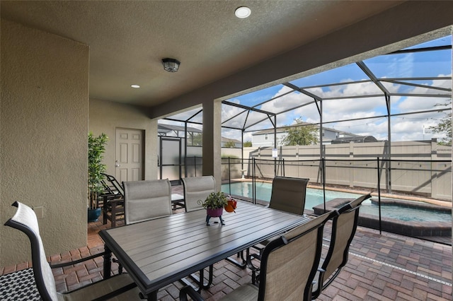 view of patio with a pool with hot tub and glass enclosure