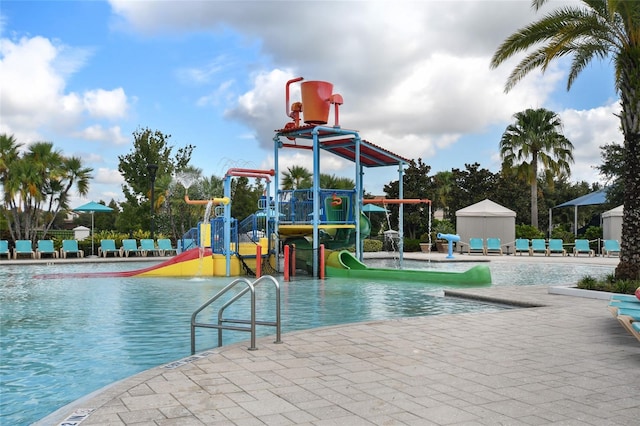 view of pool featuring a playground and a water slide