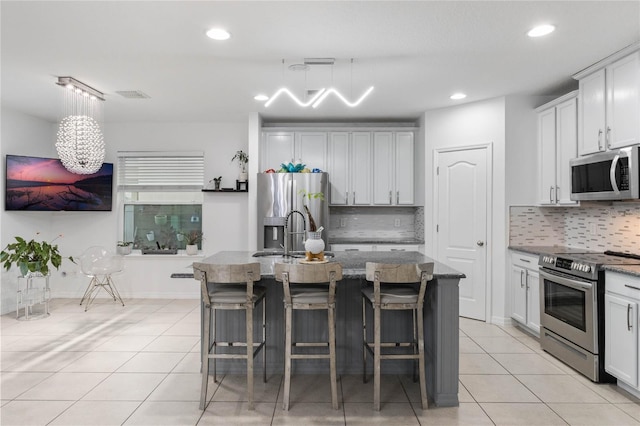 kitchen featuring a breakfast bar, a center island with sink, and stainless steel appliances