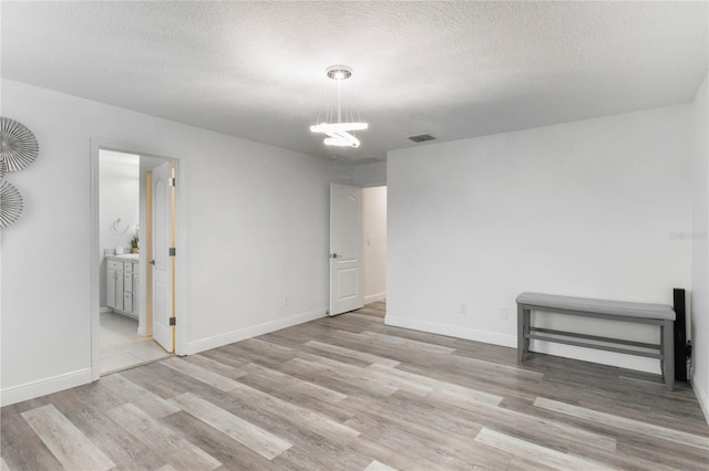 empty room featuring light hardwood / wood-style flooring and a textured ceiling