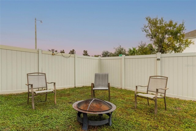 yard at dusk with an outdoor fire pit