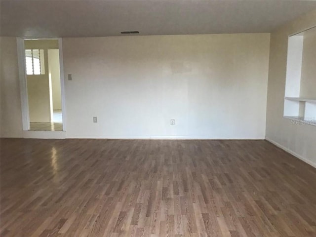 unfurnished room featuring dark wood-type flooring