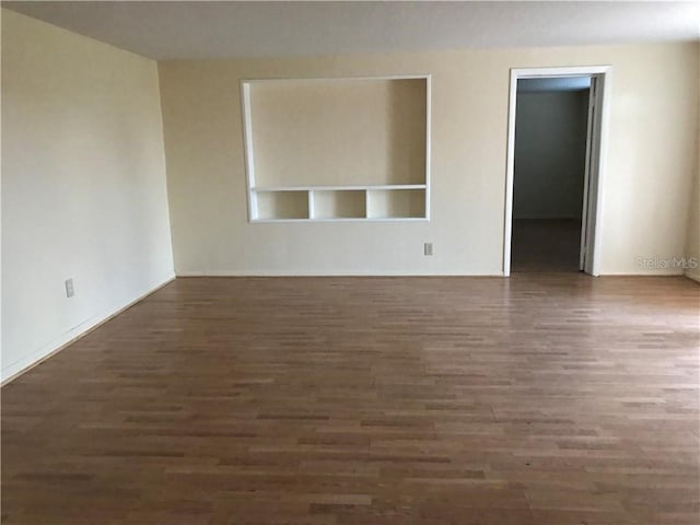 unfurnished room with dark wood-type flooring