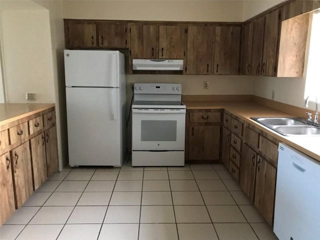 kitchen featuring white appliances, sink, and light tile patterned floors