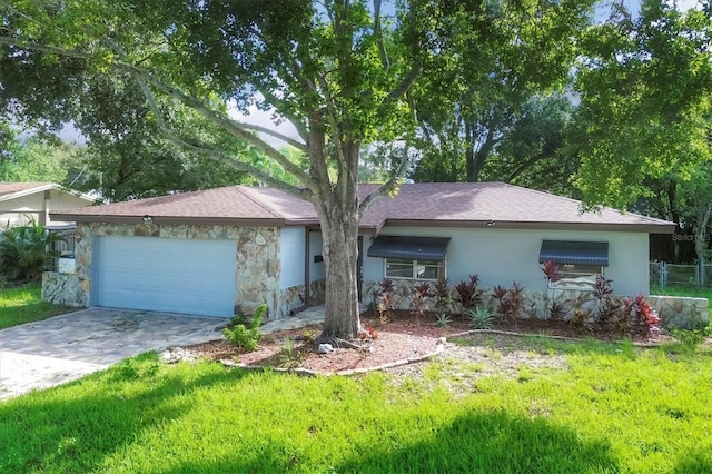 ranch-style home with a garage and a front lawn