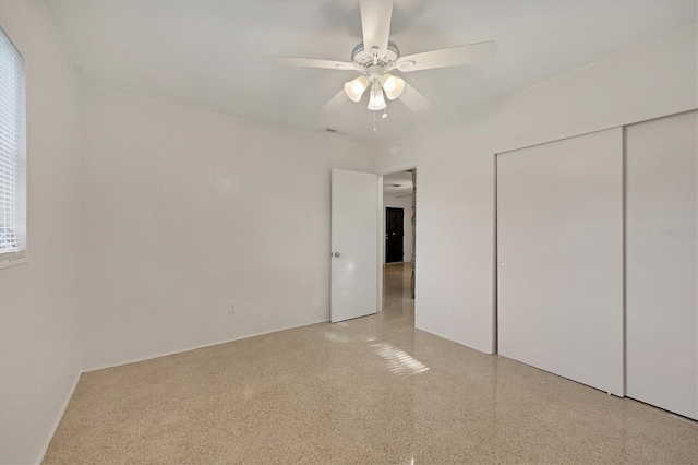 unfurnished bedroom with ceiling fan, a closet, and multiple windows