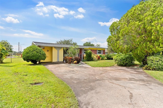 ranch-style house featuring a front lawn and a carport