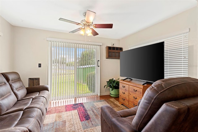 living room featuring a wall mounted AC, ceiling fan, and hardwood / wood-style flooring