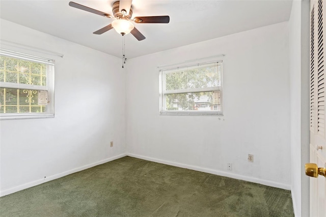 carpeted spare room with ceiling fan and plenty of natural light