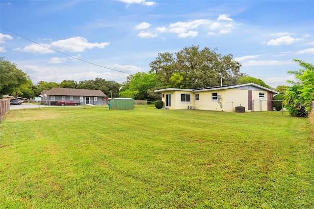 view of yard featuring a storage unit and central AC unit