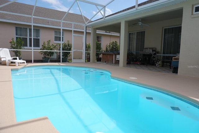 view of swimming pool with a lanai, ceiling fan, and a patio area