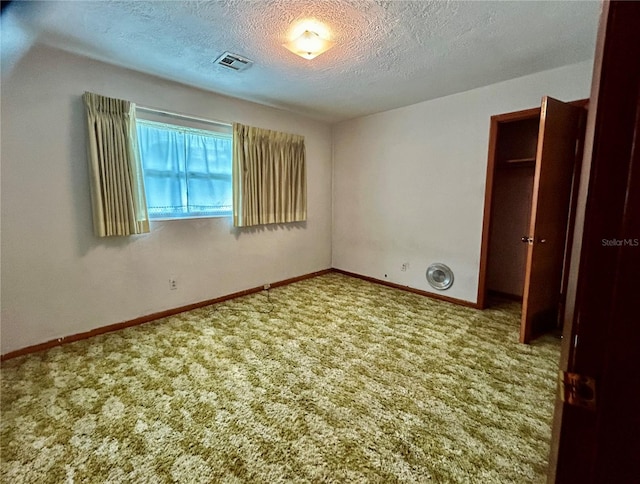 unfurnished bedroom with carpet floors and a textured ceiling