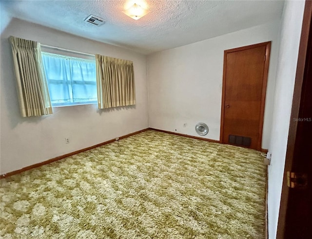 carpeted spare room featuring a textured ceiling