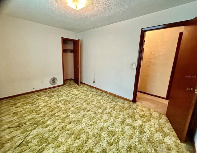 unfurnished bedroom featuring a textured ceiling and carpet flooring