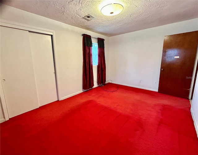 unfurnished bedroom with carpet floors, a textured ceiling, and a closet