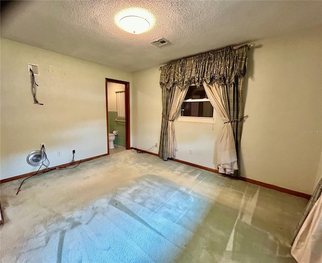 carpeted spare room featuring a textured ceiling