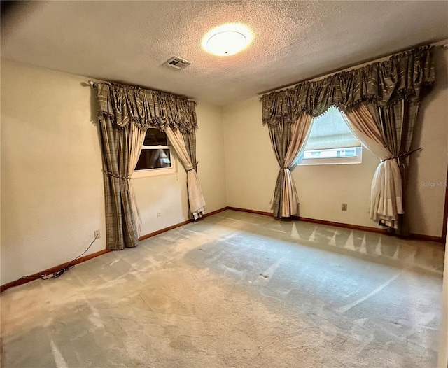 spare room with a textured ceiling and carpet floors