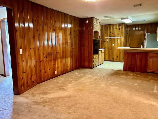 interior space with wooden walls and light colored carpet