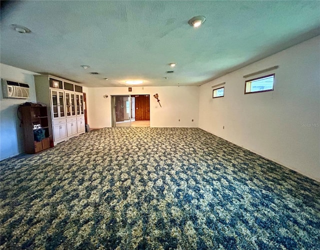 empty room featuring an AC wall unit and carpet