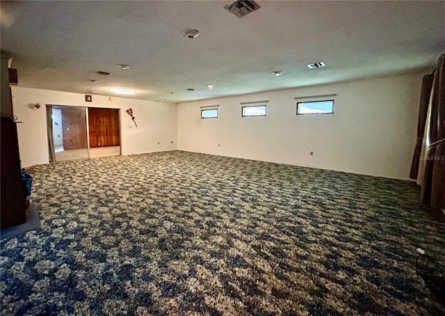 carpeted spare room with a textured ceiling