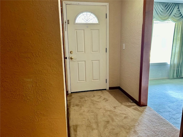 entrance foyer featuring light colored carpet