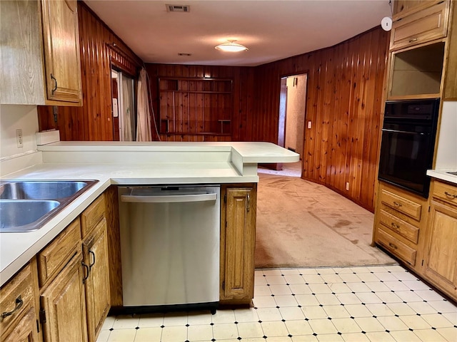 kitchen with black oven, stainless steel dishwasher, wooden walls, and kitchen peninsula