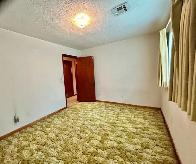 unfurnished room with carpet floors and a textured ceiling