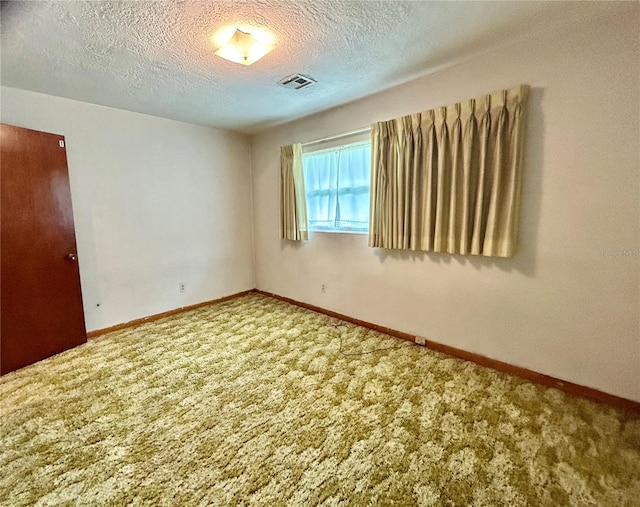 carpeted spare room featuring a textured ceiling