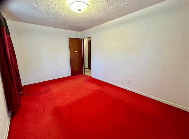 carpeted empty room featuring a textured ceiling