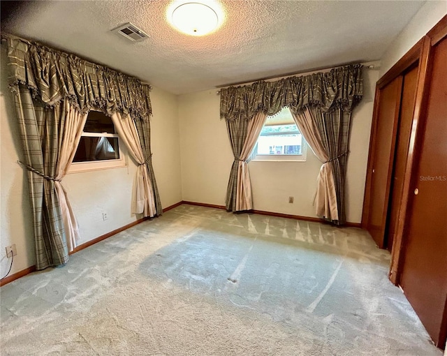 interior space with light carpet and a textured ceiling